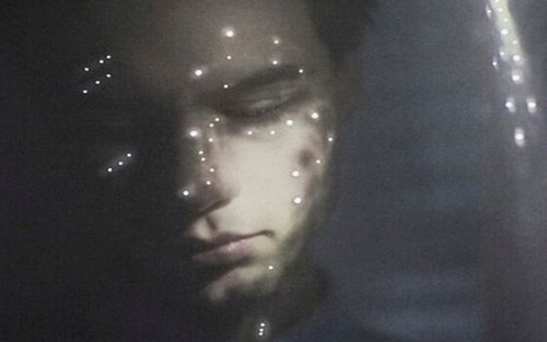 Mann mit Lichtpunkten im Gesicht