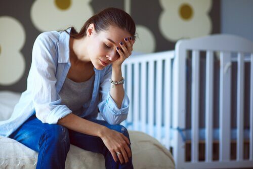 Erschöpfte Mutter vor Kinderbett