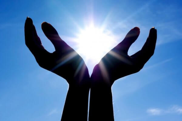 Zwei geöffnete Hände vor der Sonne