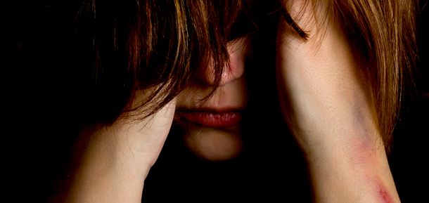 Frau die sich selbst verletzt hat und das Gesicht verbirgt