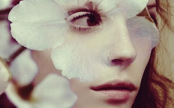 Das Gesicht einer Frau umgeben von Blütenblättern