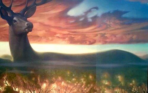 Hirsch in magischer Landschaft bei Sonnenaufgang.