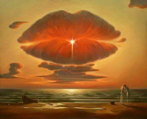 Paar küsst sich am Strand vor großer Wolke in Form eines Kussmundes.
