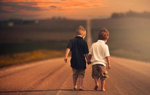 Zwei Jungen laufen gemeinsam auf einer Straße. 
