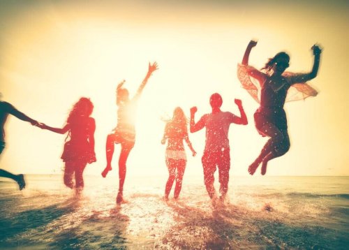 Freunde sind am Strand und springen in die Luft.