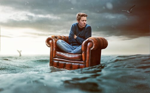 Helfen, aber nicht Eingreifen: Mann, der alleine auf einem Sessel durch das Meer treibt.