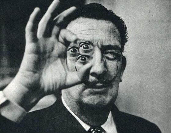 Salvador Dalí hält in seiner Hand drei Augen