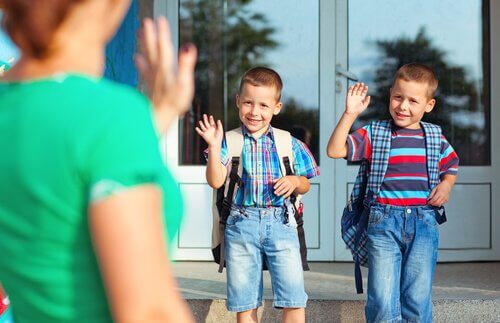 Brüder verabschieden sich von ihrer Mutter für ihren ersten Schultag
