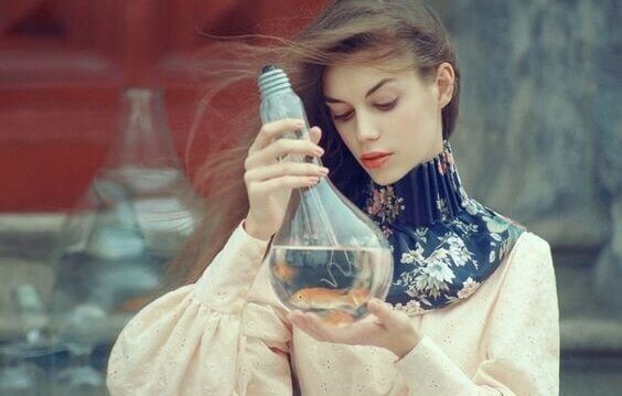 Eine Frau btrachtet eine mit Wasser gefüllte Glühbirne.