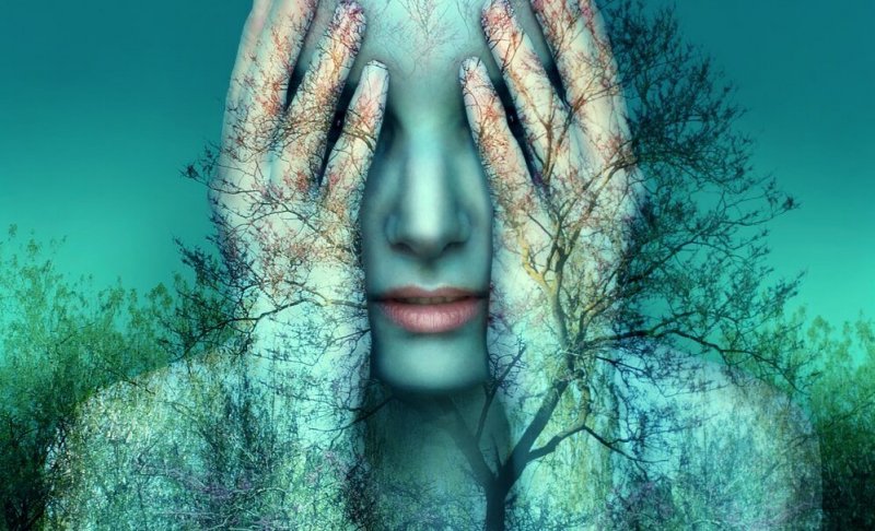 Etwas nicht zu Ende bringen kann einen verzweifeln lassen, wie diese Frau im Wald, die sich die Hände vor die Augen hält