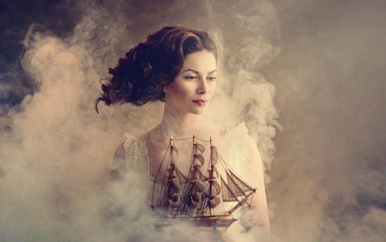 Dunkelhaarige Frau hält ein Schiff in der Hand