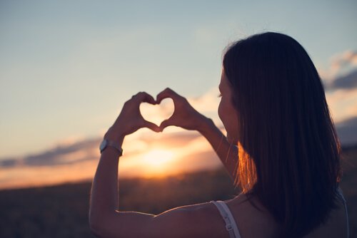 Frau formt mit ihren Händen ein Herz