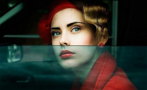 Frau mit roter Jacke schaut aus dem Autofenster