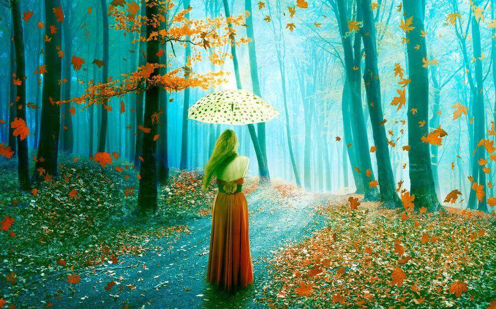 Frau mit Schirm im Herbstwald