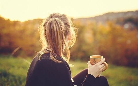 Frau mit Tasse schaut in die Ferne