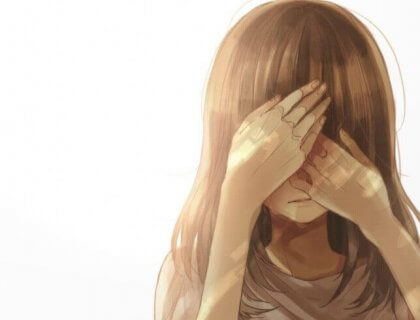 Ein Mädchen versteckt sein Gesicht hinter ihren Händen.