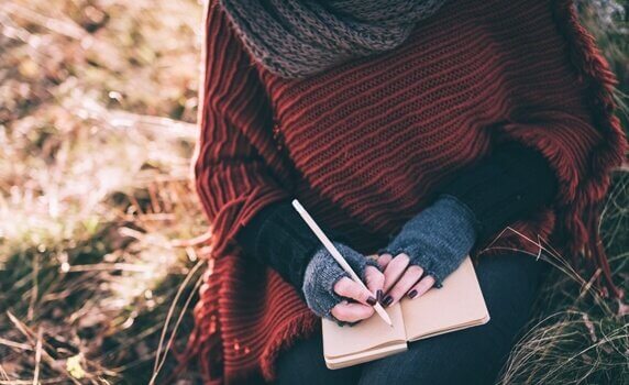 Frau zeigt, wie man ein Tagebuch schreibt