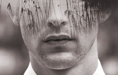 Die untere Gesichtshälfte eines jungen Mannes und Gras darüber liegend