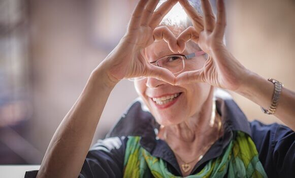 Gesundes Altern macht glücklich - ältere Dame formt mit ihren Händen ein Herz