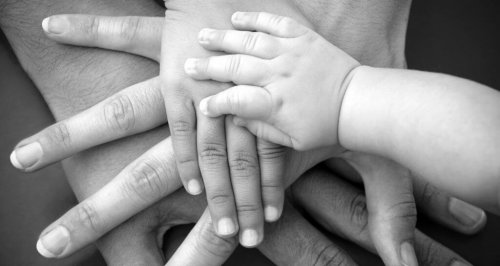 Hände verschiedener Generationen liegen übereinander