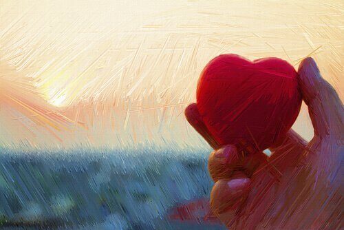 Eine Hand hält ein Herz. 