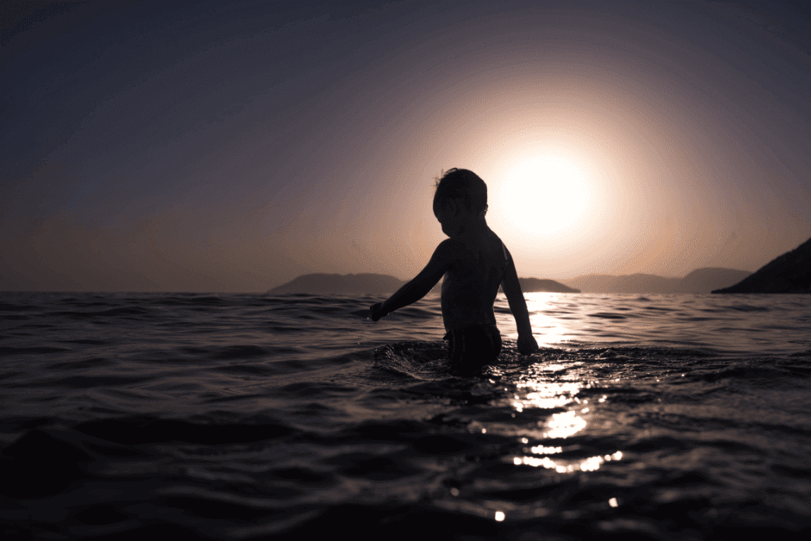 Kleiner Junge badet im Meer