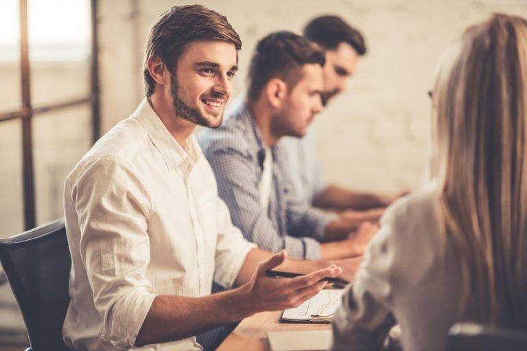 Ein junger Mann lächelt und redet in einem höflichen Tonfall