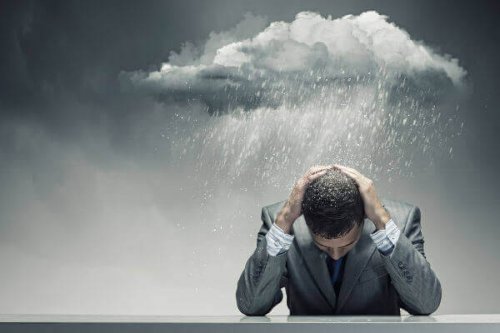 Mann mit Regenwolke über dem Kopf