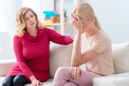 Eine Mutter kritisiert ihre bereits erwachsene Tochter. Hier liegt ein Fall von Mom-Shaming in der Familie vor.