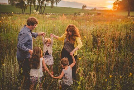 Eine Familie spielt und tanz auf einer grünen Wiese