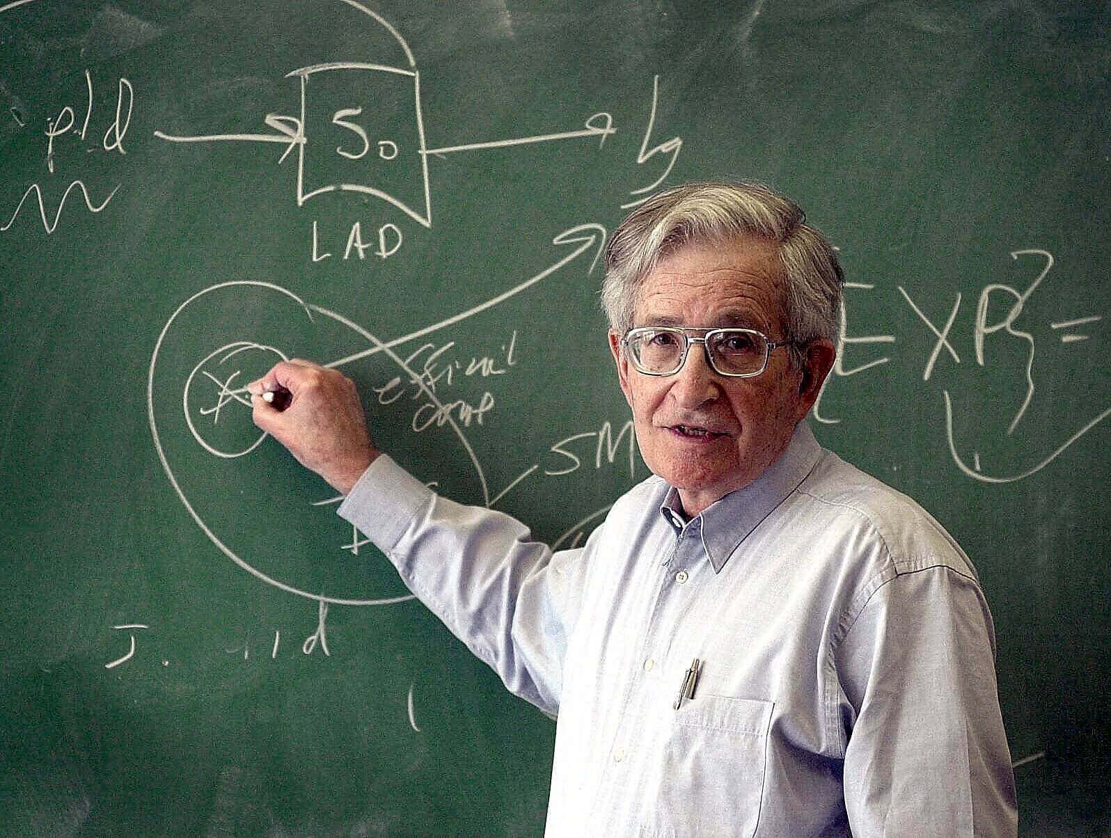 Noam Chomsky schreibt auf einer Tafel