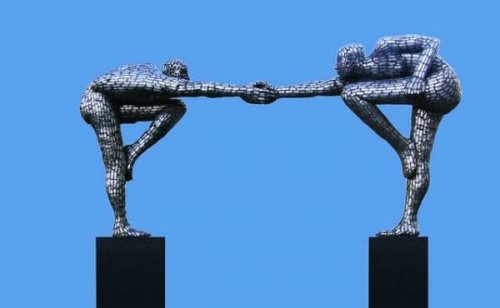 Eine Statue, die zwei Menschen zeigt, die sich an den Händen berühren. 