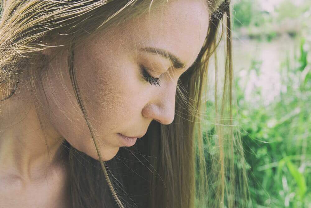 Frau schaut traurig nach unten