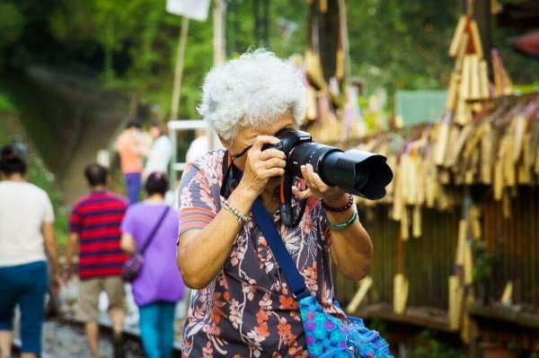 Eine ältere Frau macht Fotos. 