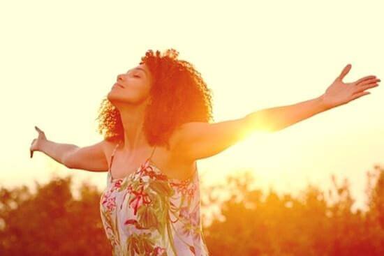 Frau mit ausgestreckten Armen und geschlossenen Augen