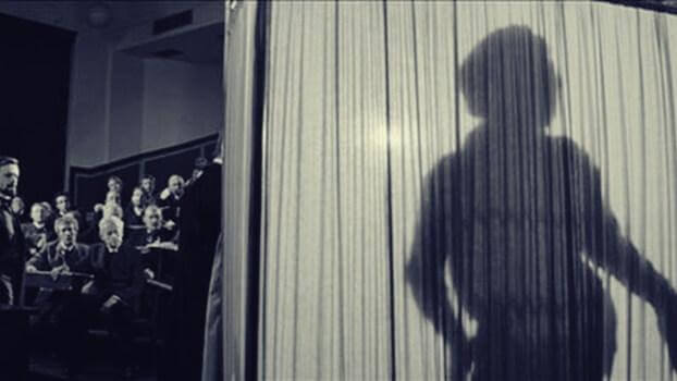 Der Schatten des Elefantenmenschs auf einem Vorhang sichtbar