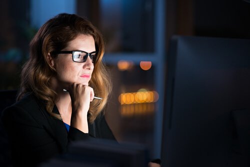 Eine Frau arbeitet nachts am Computer.