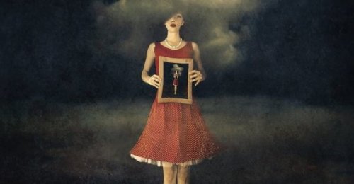 Frau, die ein Portrait von sich selbst hält