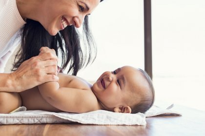 Eine Frau lächelt ihr Baby an.