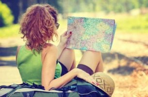 Frau mit Hut schaut auf Landkarte