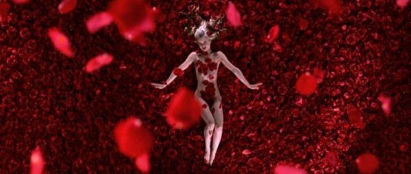 Filmszene aus American Beauty, auf der sich ein nacktes Mädchen auf Rosenblättern rekelt.