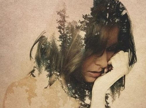 Eine traurige Frau, aus deren Kopf ein dichter Wald entsteht