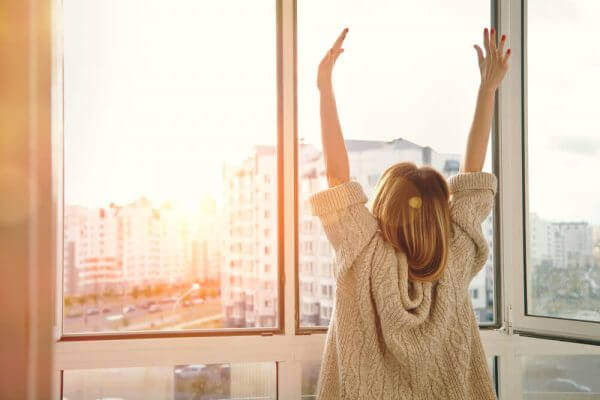 Eine Frau hat es geschafft, sie ist ausgeglichen und streckt sich im Sonnenaufgang.