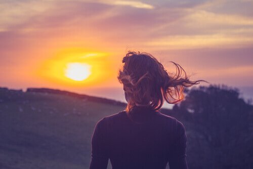 Eine Frau blickt in den Sonnenuntergang.
