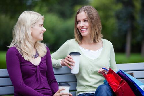 Frauen unterhalten sich auf einer Parkbank.