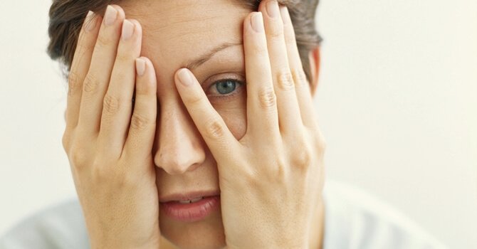 Eine Frau hat ihre Hände vors Gesicht geschlagen.