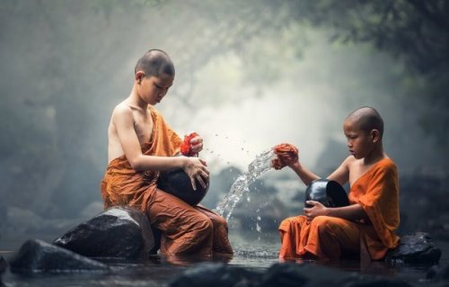Zwei junge buddhistische Mönche schöpfen Wasser. 