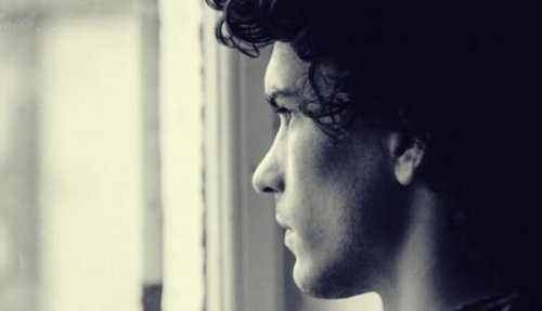 Ein junger Mann schaut aus einem Fenster