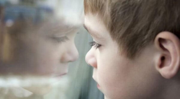 Ein Junge schaut durch ein Fenster