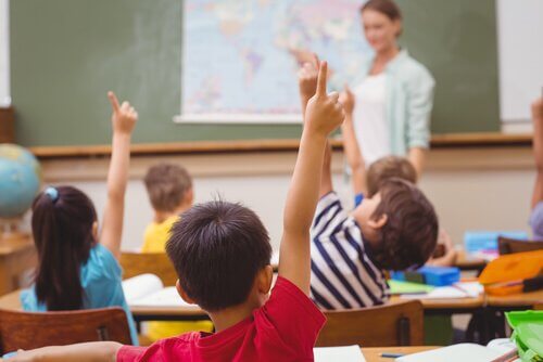 Kinder melden sich im Unterricht
